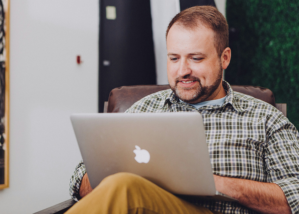 man with laptop having online orthodontic appointment
